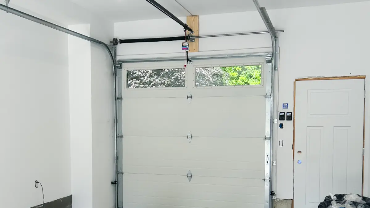Inside view of a garage door installed by Garage Door Solutions Inc., showing both vertical tracks running plumb up each side of the opening and curving into the horizontal tracks along the ceiling