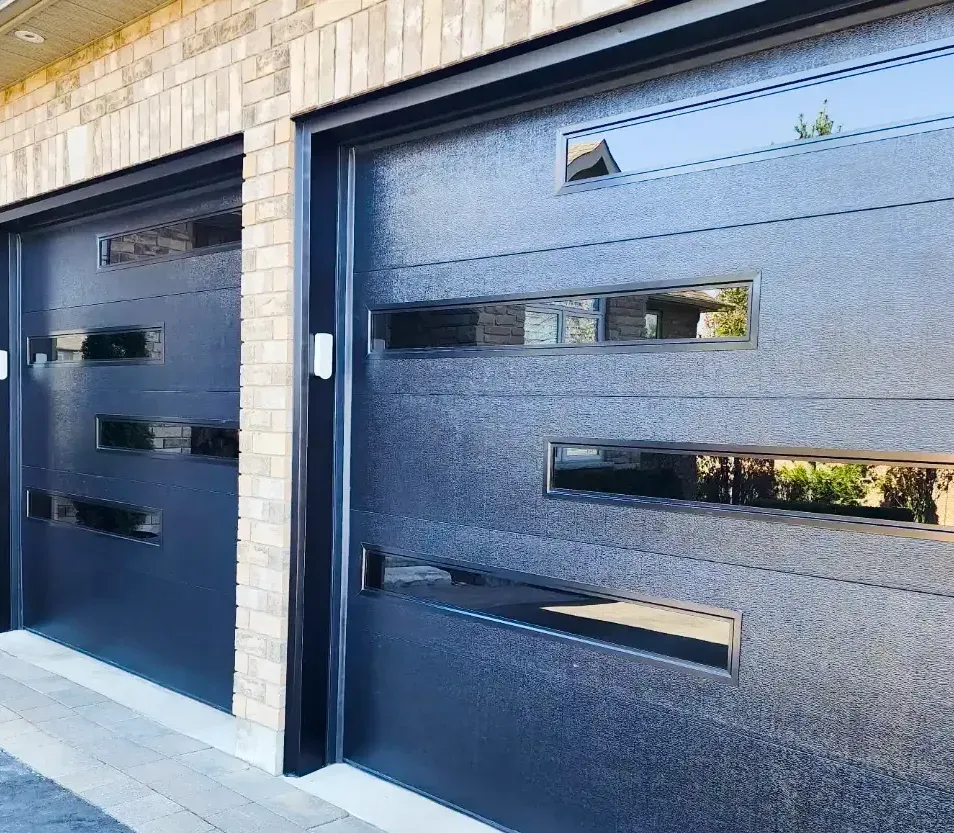 Two black modern garage doors with linear glass installed on a Byron, London home