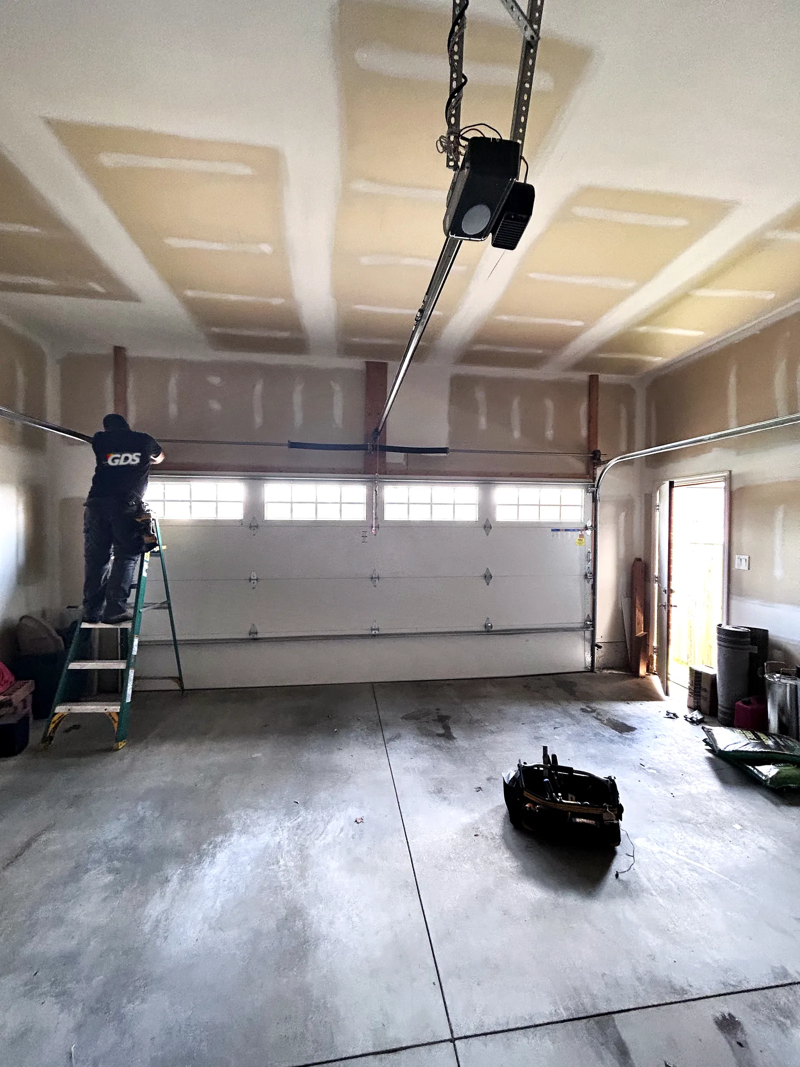 New ceiling-mounted garage door opener and rail installed above a new insulated door in a London, Ontario garage