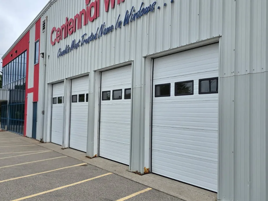 Four white insulated commercial garage doors installed along the side of a Hyde Park, London business