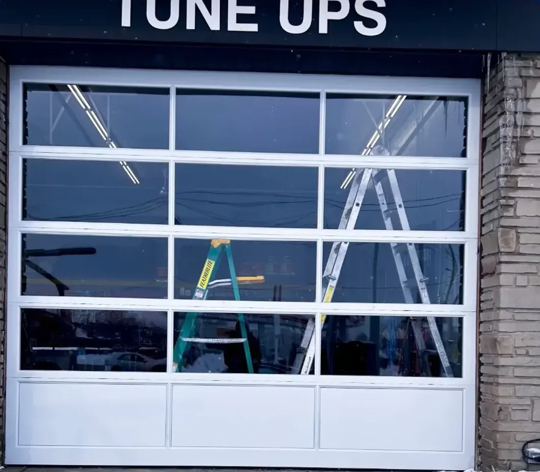 White-framed full-view glass commercial garage door installed at an Old East Village, London shop