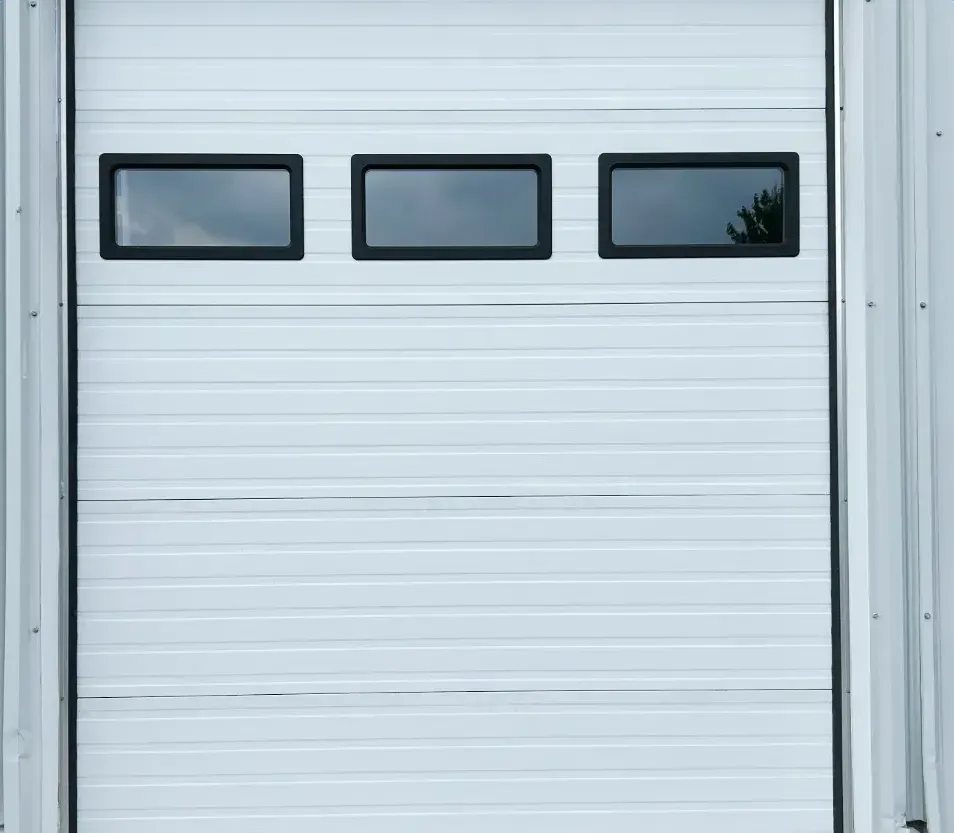 White commercial garage door with a row of windows installed on a steel building in Pond Mills, London