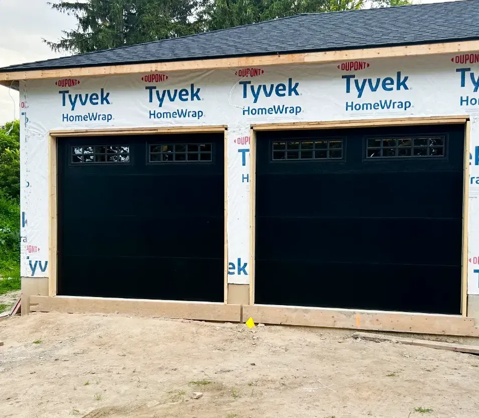 Two black carriage-style garage doors installed on a new-build garage in Riverbend, London