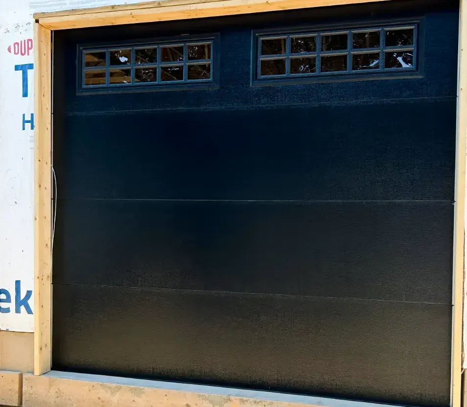 Black carriage-style insulated garage door installed on a new-construction home in Sunningdale, London