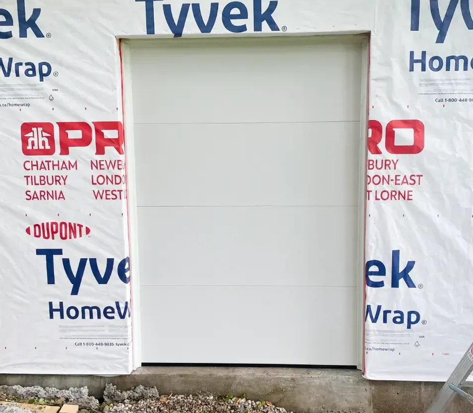 White modern flush insulated garage door installed on a new-construction home in Talbot Village, London