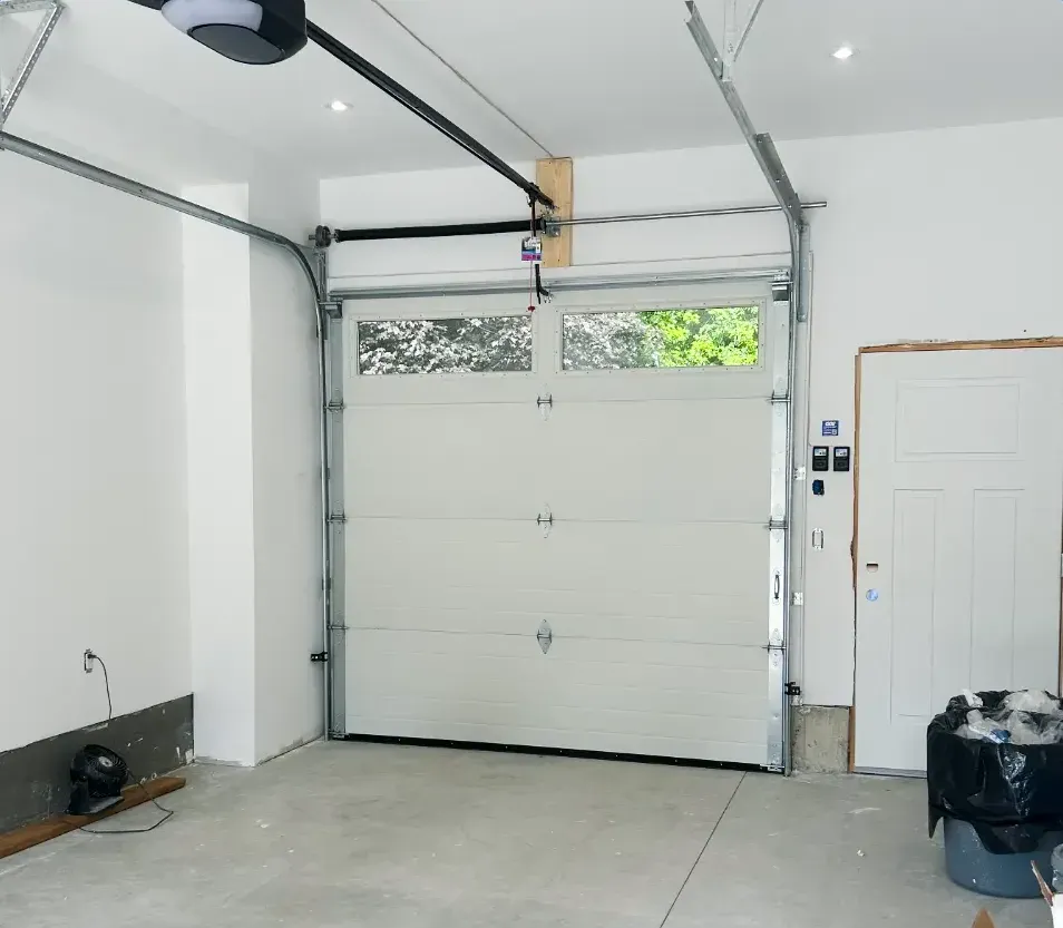 New white insulated garage door and opener installed, viewed from inside a Westmount, London garage